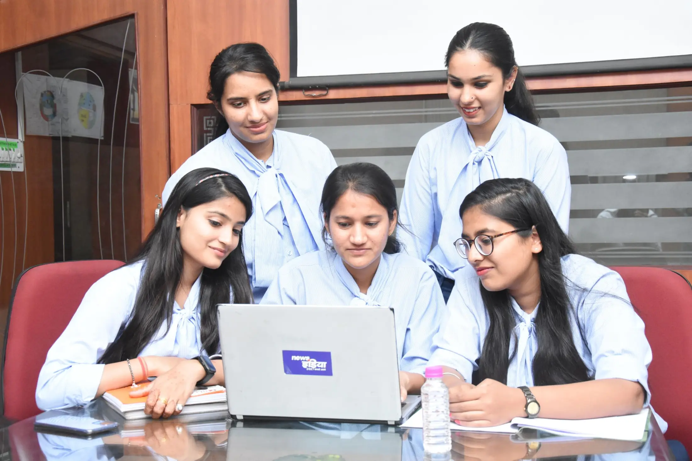 Indian women collaborating around a laptop in