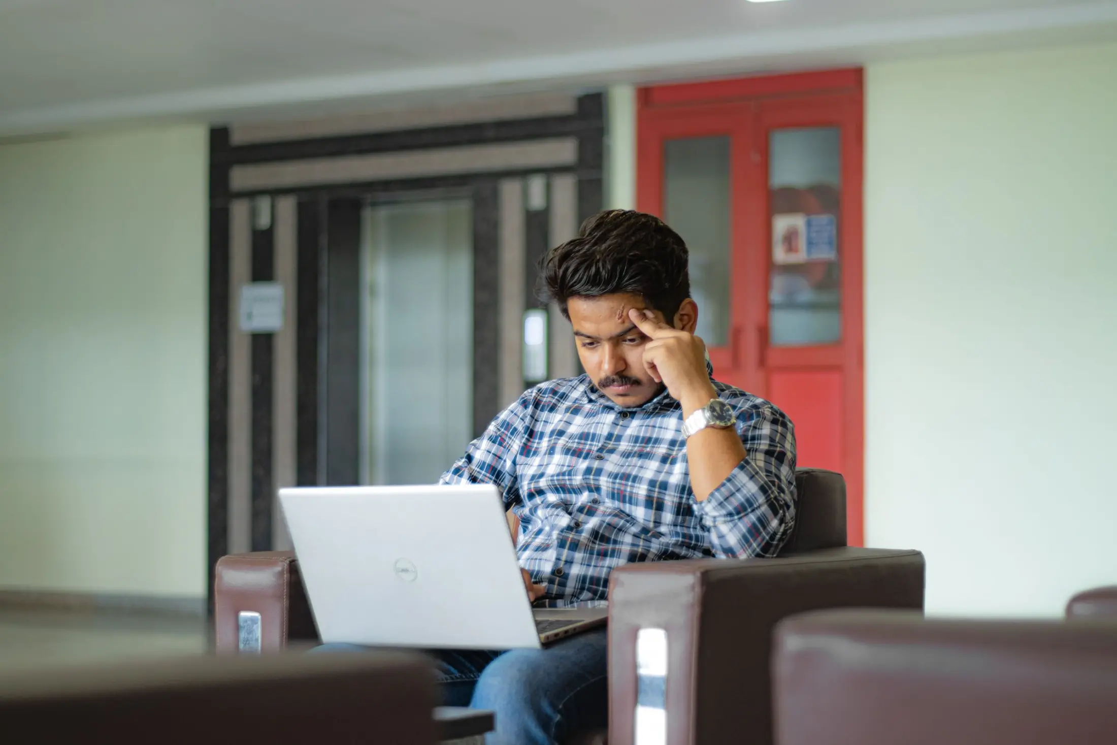 Young Indian professional focused on laptop work in Delhi
