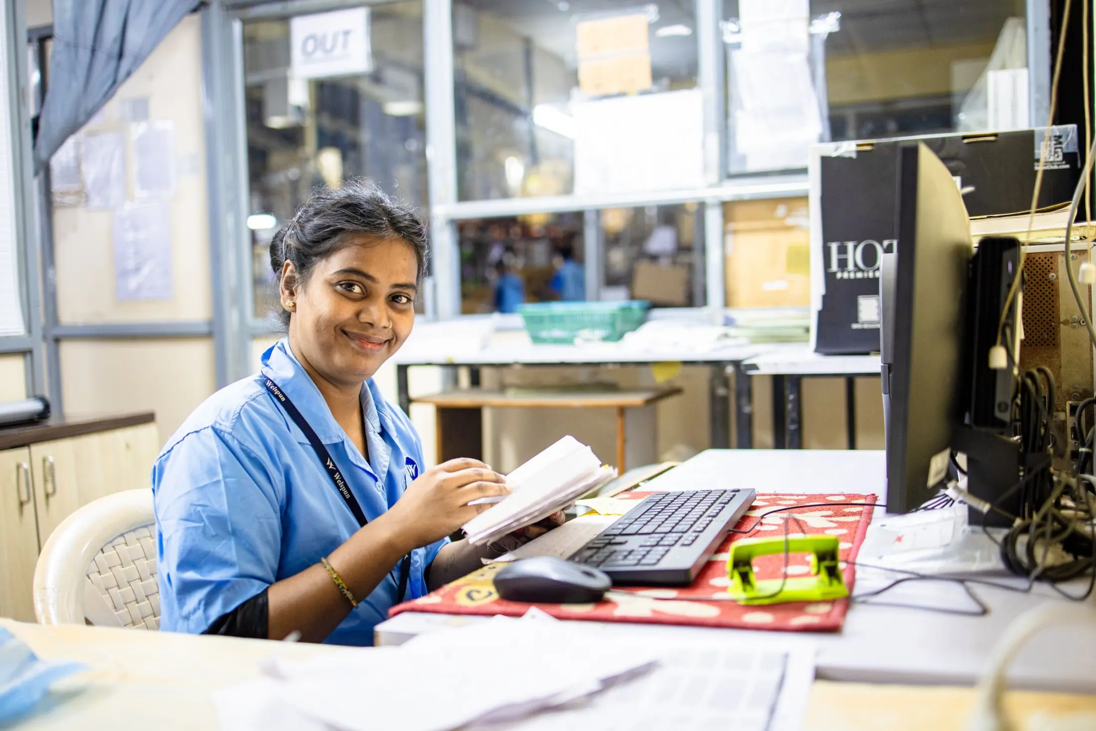 Indian professional reviewing documents at an office workstation