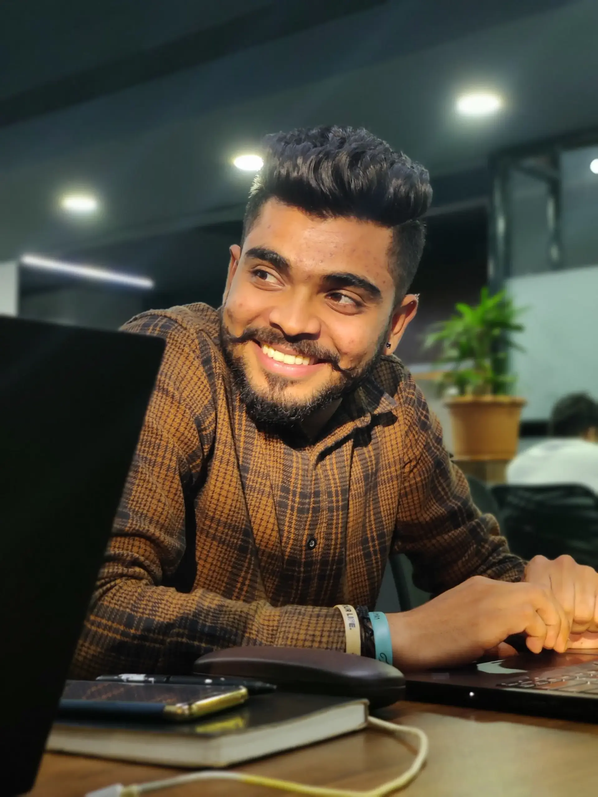 Indian professional working on a laptop in a modern office